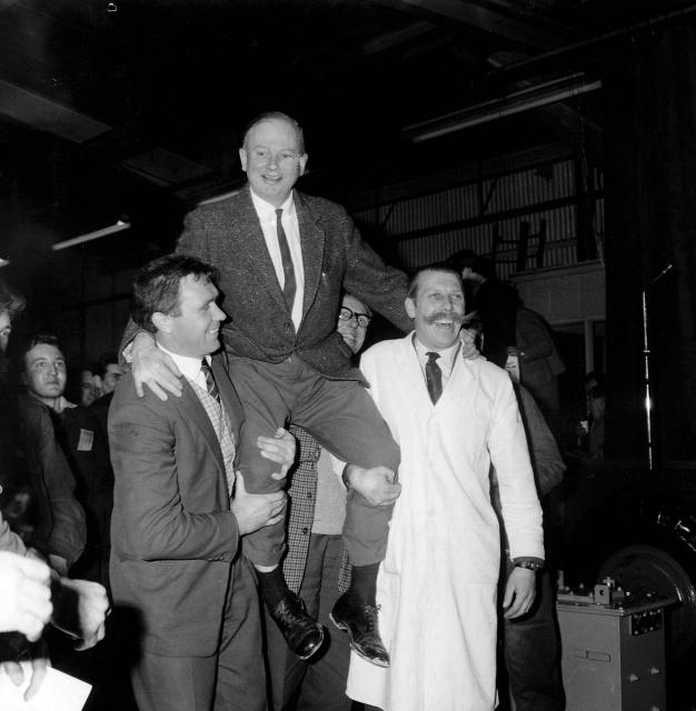 1964__Mr_Bamford_is_held_shoulder_high_by_employees_Bill_Hirts__left__and_John_Wheeldon_after_annoucing_a__250_000_employee_bonus_02.jpg