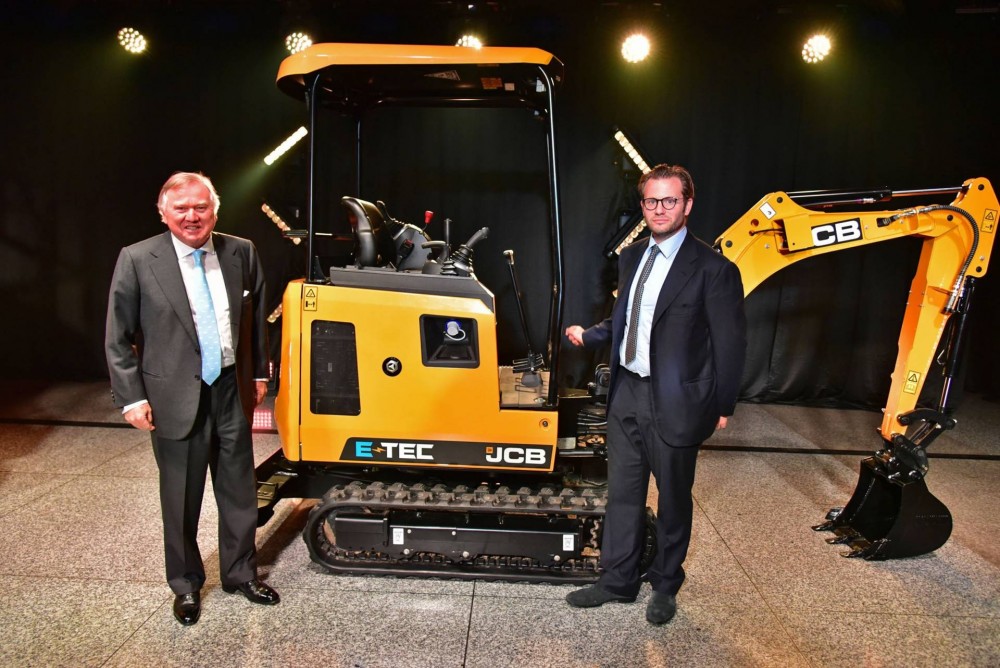 Lord Bamford präsentiert gemeinsam mit seinem Sohn Georg den weltweit ersten Elektrobagger von JCB: den 19C-1 E-TEC