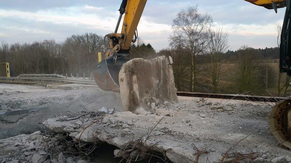 Aus der Betonstruktur wurden einzelne Stücke mit rund 1 m Kantenlänge herausgetrennt, auf die noch bestehende Fahrbahn gedreht und mit konventioneller Technik zerkleinert