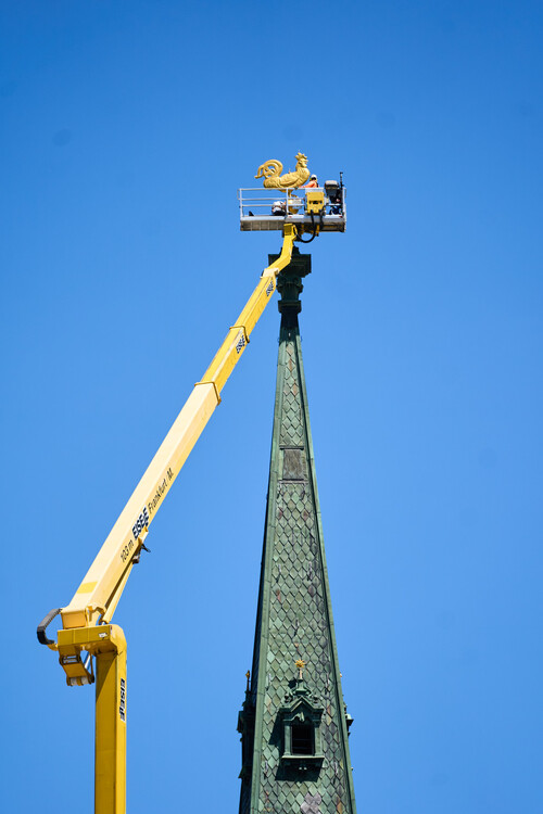 Präzisionsarbeit an der Turmspitze Aus dem Arbeitskorb wird der Wetterhahn an seiner Position montiert..jpg
